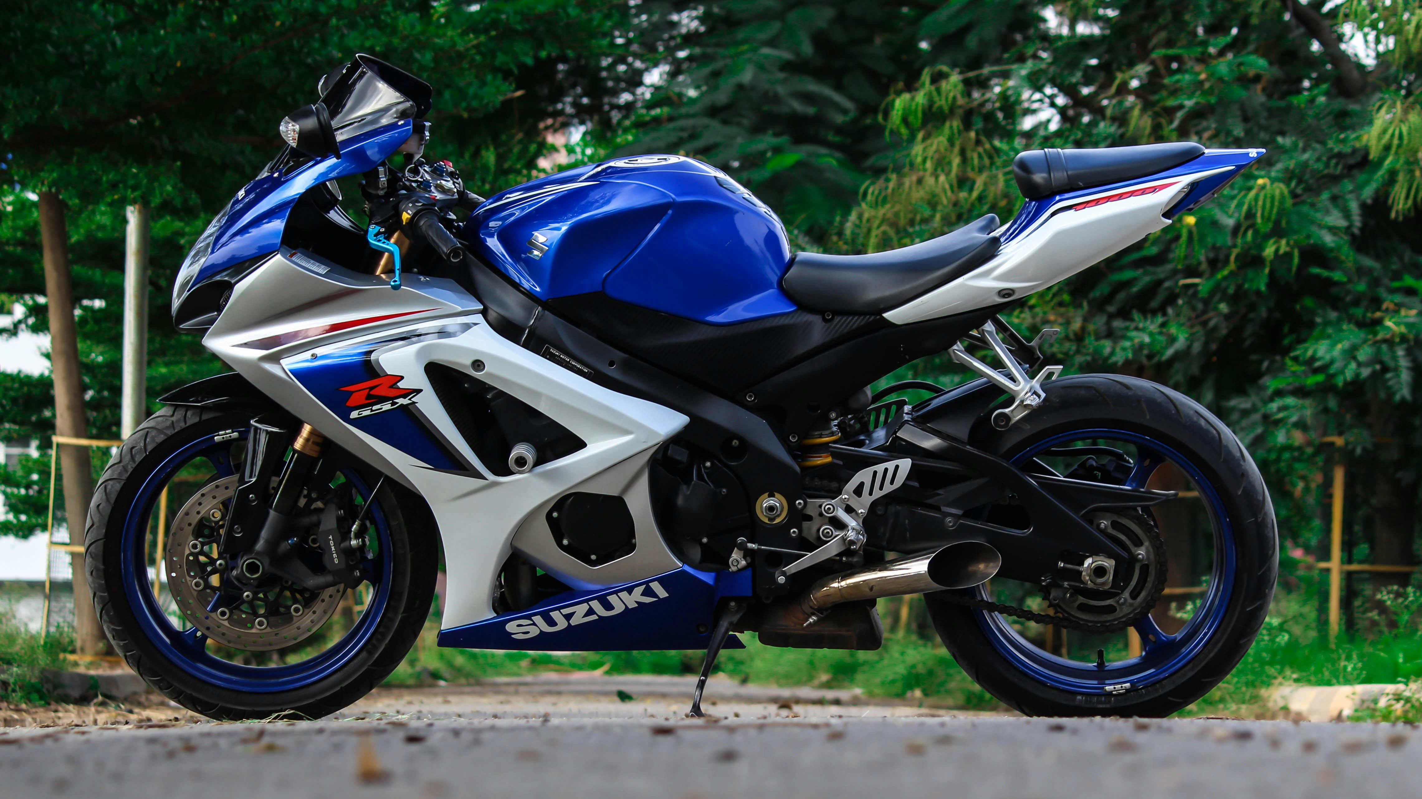 blue and white Suzuki sports bike parked during daytime